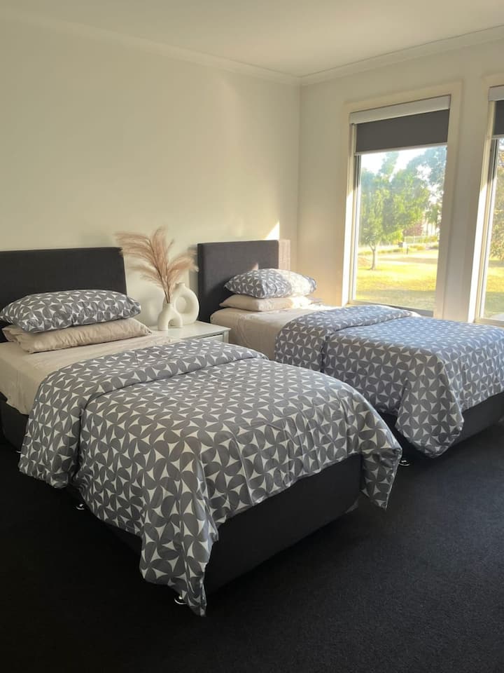 Chumba cha tatu cha kulala
Chumba kilichojaa mwanga kilicho na vitanda viwili vya mtu mmoja (sukuma pamoja kwa wanandoa), kabati zilizojengwa ndani na zulia lenye starehe. Inatazama Drey Park, ikitoa sehemu yenye utulivu, anuwai kwa ajili ya kulala au kupumzika kwa utulivu.