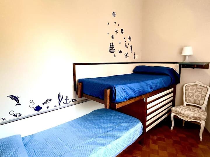 تحتوي غرفة النوم الثانية على سريرين متماثلين تم تكوينهما في إعداد سرير بطابقين مع مساحة عمل/مكتب مخصص 