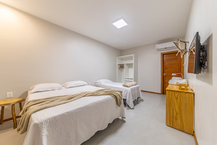 Apartman na gornjem katu, velik i udoban, s bračnim krevetom i jednostrukim krevetom. Ima klima-uređaj, TV, otvoreni ormar i minimalistički dekor s rustikalnim detaljima. Idealno za odmor i praktičnost.