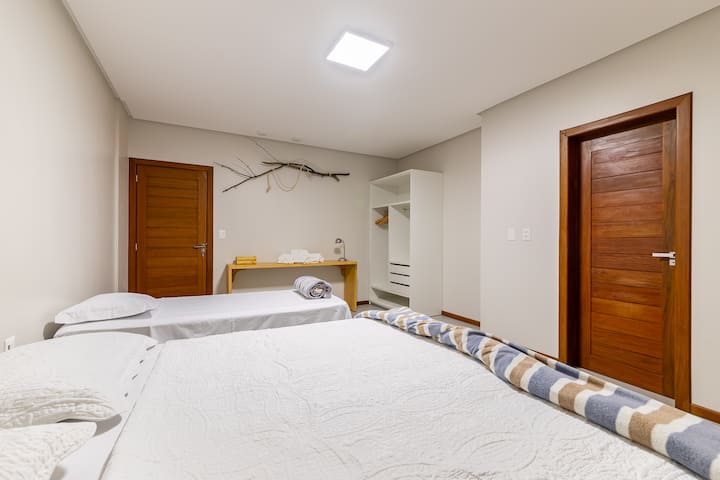 Apartman na gornjem katu s bračnim krevetom i krevetom za jednu osobu, idealan za obitelji ili prijatelje. Veliki prostor, s klima-uređajem, otvorenim ormarom, pomoćnim stolom i ugodnim uređenjem s prirodnim elementima. Udobnost i stil na jednom mjestu.