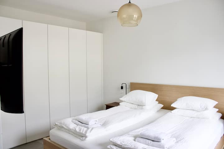 Დიდი გარდერობი ტანსაცმლისა და ნივთების შესანახად. Ბრტყელეკრანიანი ტელევიზორი კედელზეა მიმაგრებული, ხოლო საწოლისპირა ლამპები უზრუნველყოფს რბილ განათებას საღამოს განტვირთვისთვის.