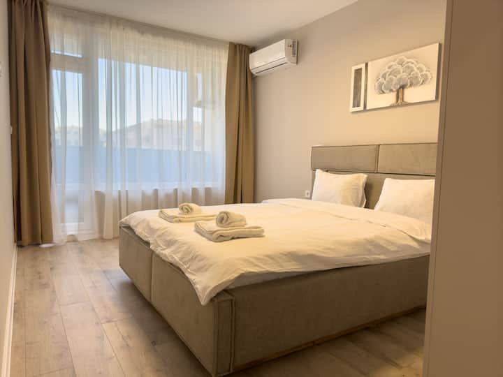 Dormitorio luminoso con una lujosa cama doble, tonos neutros relajantes y acceso directo a un balcón soleado.