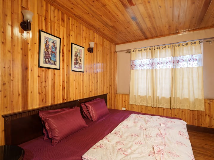 The master bedroom features an attached bathroom, a king-size bed, beautiful wooden flooring, and all the essential amenities for a relaxing stay. Room heaters are provided for added warmth. 