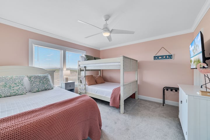 Chini ya ukumbi kutoka ghorofa ya pili King chumba katika kila nyumba kuna chumba cha kulala chenye Malkia 1 na ghorofa ya ukubwa kamili. Kuna televisheni janja hapa pia ili wageni wafurahie kutazama vipindi wanavyovipenda, au wanaweza kutumia koni ya michezo ya kompyuta.