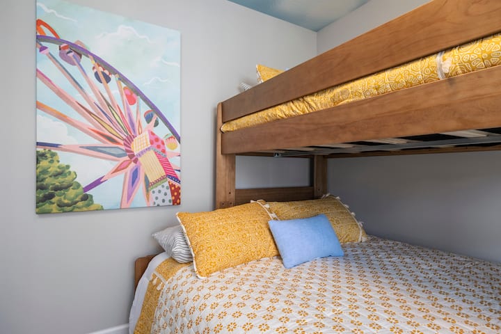 Добре дошли в стаята на увеселителния парк! С двуетажно легло с размер Queen и две единични легла с размер XL, това весело пространство е идеално за деца или за тези, които са млади по душа. Ярки цветове, уютно спално бельо и забавна щампа на виенско колело внасят игрива енергия в почивката ви в Брансън.