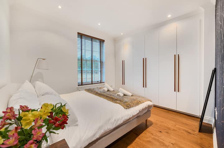 Svijetla i elegantna druga spavaća soba s udobnim bračnim krevetom, puno prostora za pohranu i opuštajućim pogledom na Bushy Park.