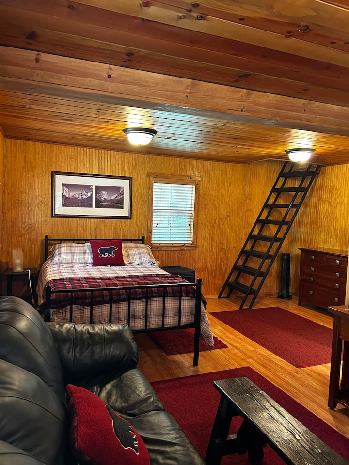 Lit queen size, bureau et mini-réfrigérateur à l'intérieur de la chambre.