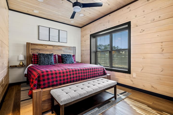 Главната спална соба на главното ниво го спојува удобниот шарм на колибата со современ дизајн, нудејќи одмор по денот исполнет со авантури.