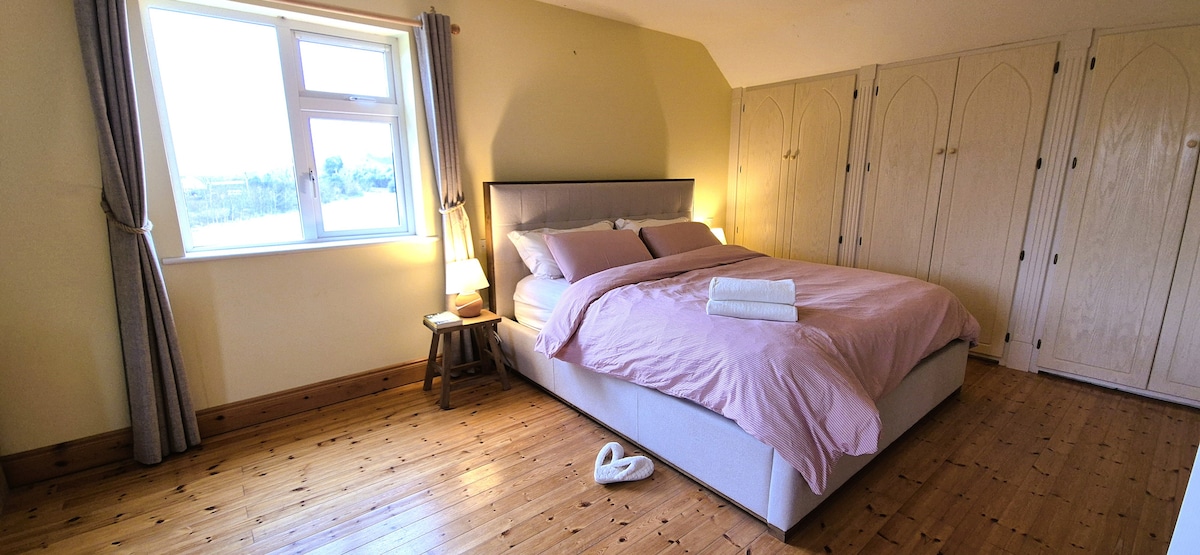 大型主套房配有超大双人床、工作空间、步入式衣柜和全套卫生间。 醒来时可欣赏乡村美景！