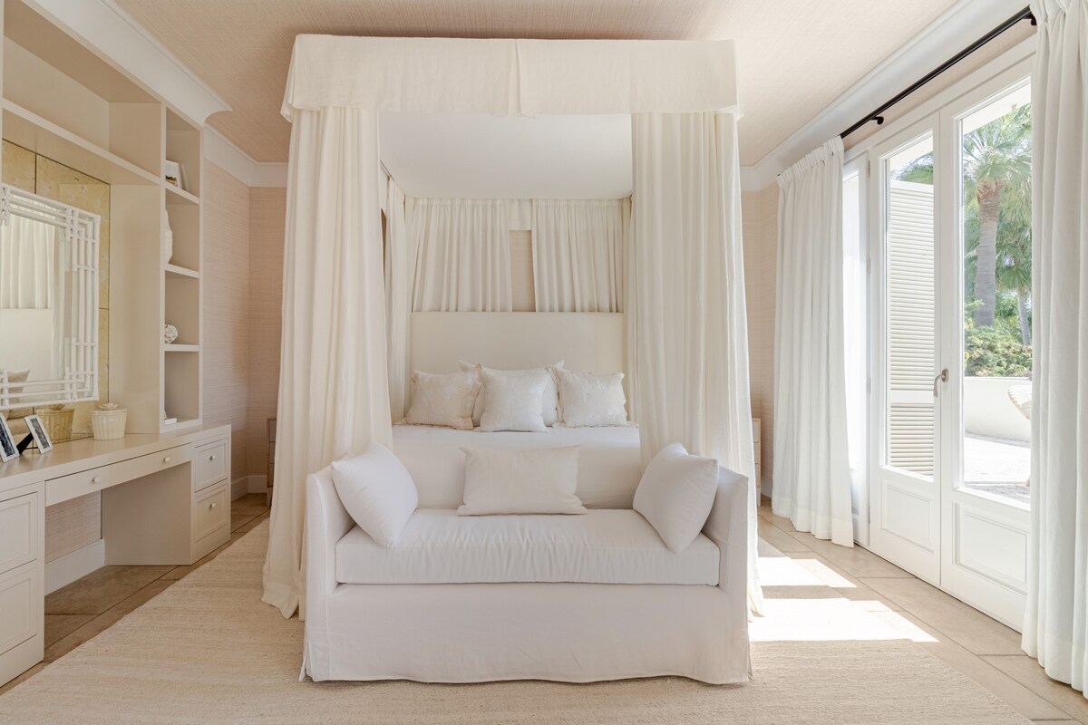 Elegant and light-filled master suite with a four-poster canopy bed, cozy seating area, and direct access to the terrace through French doors. A calm and luxurious private retreat. En-suite bathroom with bath tub connected to the master suite.