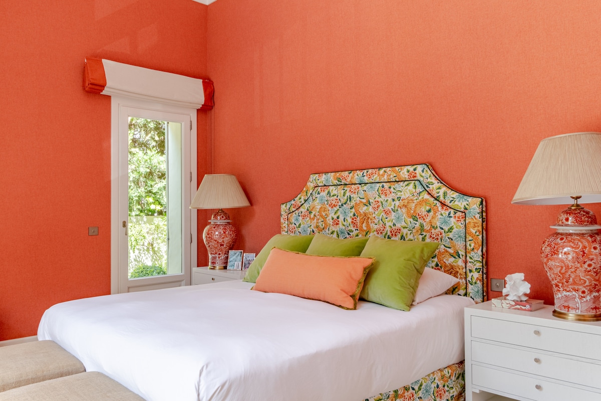 Spacious and cheerful bedroom with a queen bed, vibrant décor, large windows for natural light. A bright and comfortable retreat for a restful stay.