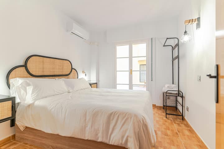 غرفة نوم بسرير مزدوج، لوح خشبي مضفر، طاولات بجانب السرير مع مصابيح، خزانة مدمجة، رف معطف معدني وتكييف هواء. يمكن الوصول إلى شرفة وجدران بيضاء وأرضيات باركيه. تصميم عملي ومضاء جيدًا.
