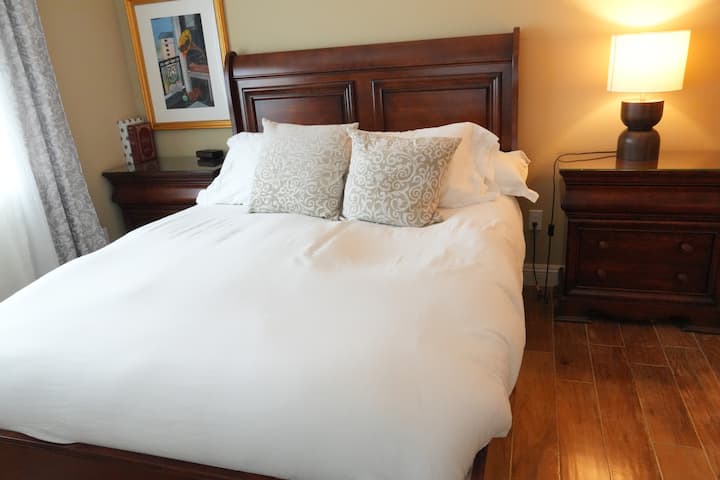 Kitanda cha starehe cha malkia katika chumba chetu cha wageni ambacho kinaangalia roshani/eneo la baraza.