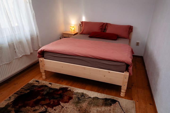 Svijetla soba s pažljivo izrađenim drvenim namještajem. Atmosfera, stvorena od prirodnih i kvalitetnih materijala, donosi spokoj i udobnost, pretvarajući prostor u savršeno utočište za odmor i opuštanje, daleko od svakodnevne rutine.