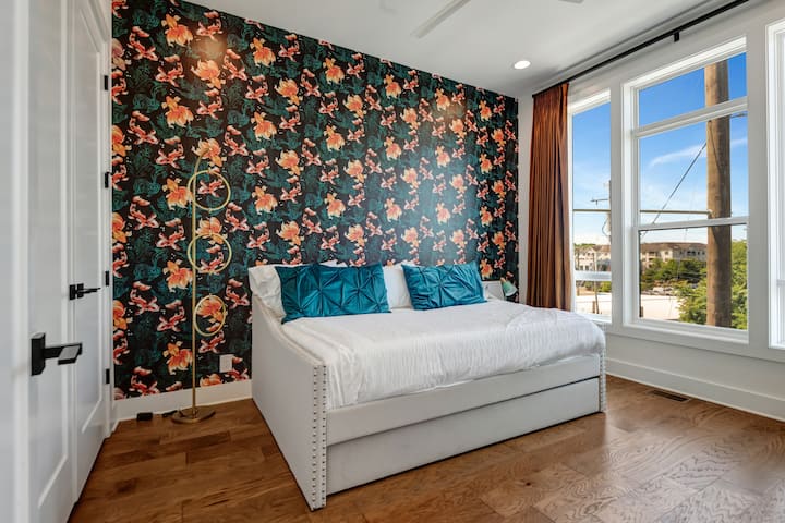 *Esta suite de invitados en la planta principal ofrece una cama tamaño queen con una cama nido completa, baño completo, armario grande y papel pintado/revestimientos de ventanas personalizados.