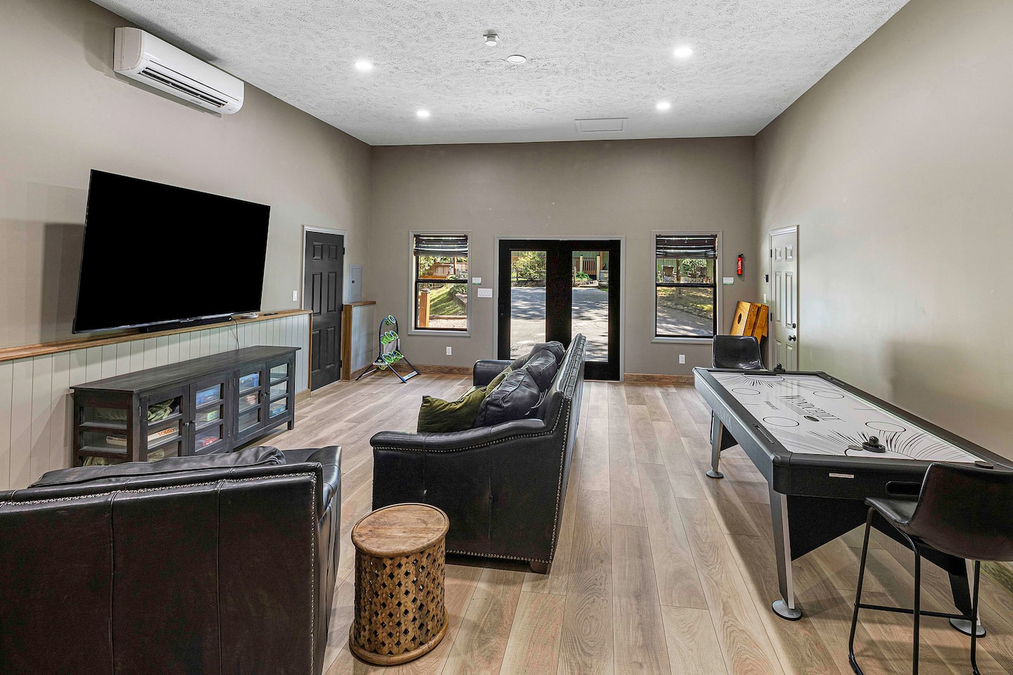 Claim the leather sofa and oversized chair while the air hockey table's going and the door's open to the deck - the gues