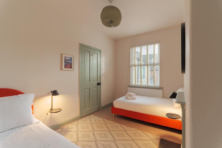 At the rear of the house, with two single beds, bedside shelves and lamps, built in clothes hanging and shelf for luggage.