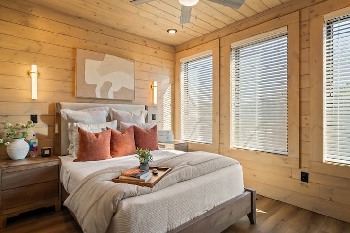 This cozy bedroom features a queen bed with a plush foam topper for added comfort, a TV for easy relaxation, and a stylish dresser to store clothes and personal items—blending comfort and convenience in a welcoming space. Located on second level.