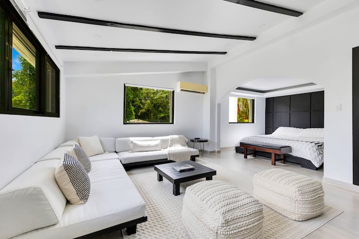Experience luxury in this master suite, featuring an open layout with a spacious living area, large sectional, and king size bed. For ultimate relaxation, unwind in the private jet tub or separate rain-shower, and enjoy panoramic views.