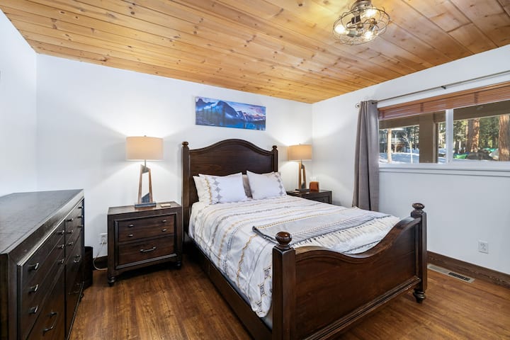 ห้องหลักพร้อมเตียงควีนไซส์ 1 หลังตู้เสื้อผ้าตู้เสื้อผ้าและโต๊ะข้างเตียง 2 ตัว