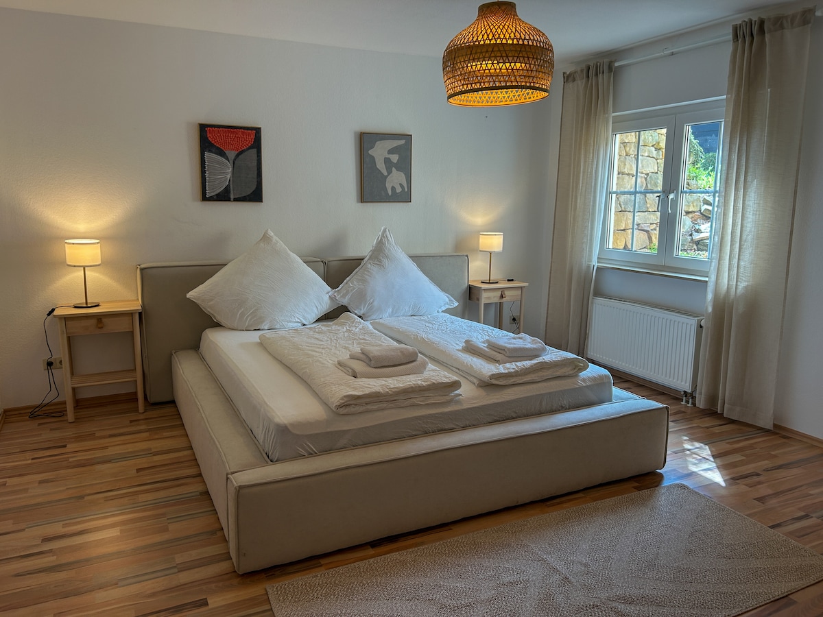 Habitación luminosa con una acogedora cama tamaño king (1,80 × 2,00 m), elegantemente amueblada y con mucha luz natural. Ideal para relajarse después de un buen día en la zona.