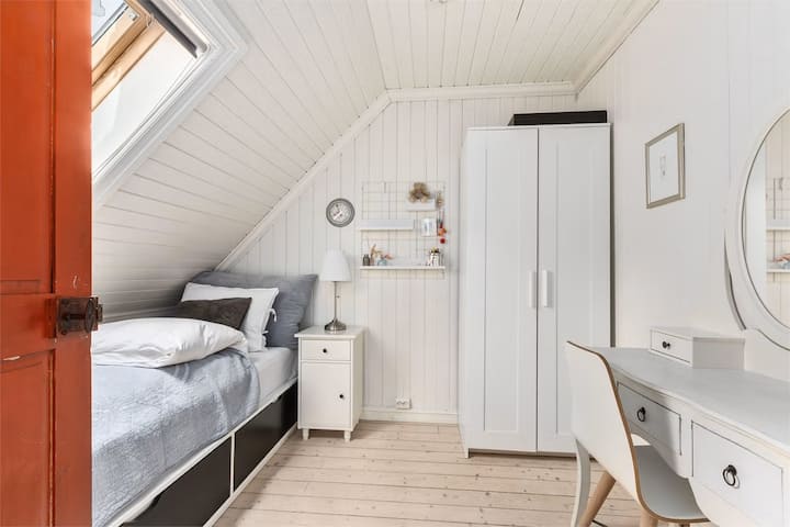 Une chambre lumineuse et fonctionnelle avec un bon espace de rangement. 