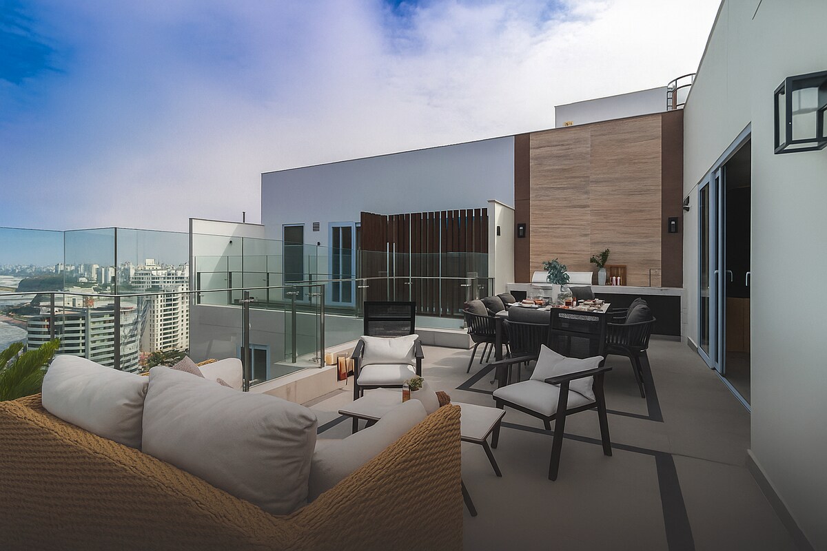 An outdoor terrace is displayed, featuring a comfortable seating area with soft cushions and stylish armchairs. A dining table is set nearby, complemented by modern glass barriers that offer clear views of the surroundings. The layout promotes relaxation and social gatherings in a spacious setting.