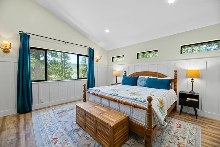 This upper level primary suite has 1 California king bed, hardwood floor, a 65” Samsung TV with sound bar, an ensuite bathroom (Bathroom #3), and a sitting area with a desk.