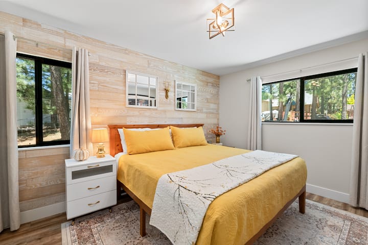 This lower level bedroom is a primary bedroom that has 1 California king bed, hardwood floor, a 45” Samsung TV, and a walk-in closet.