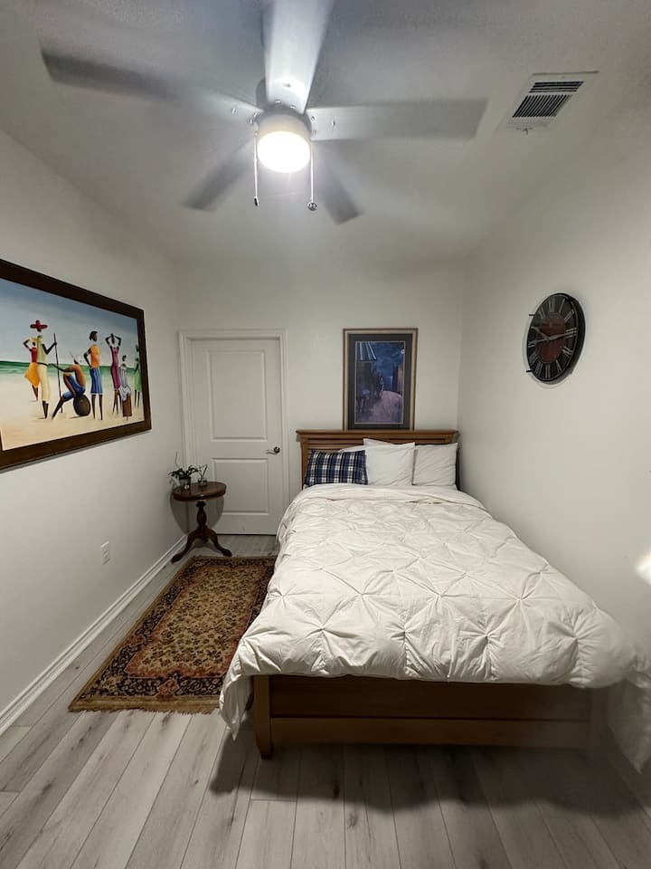 Lit en bois massif de taille normale disponible avec bureau et télévision.