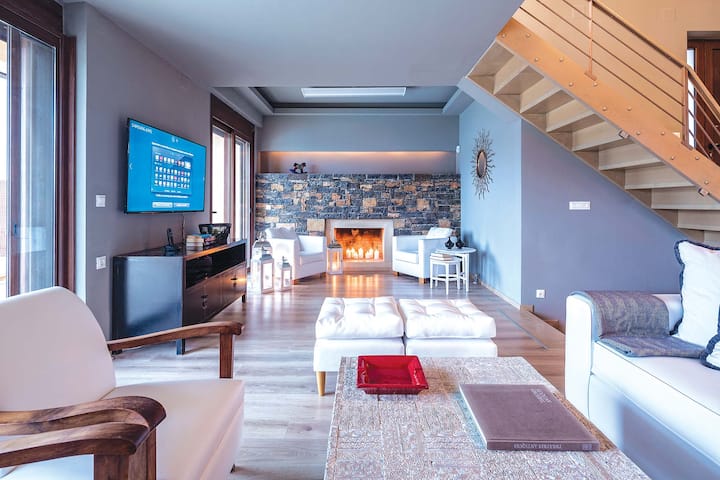 Upper Level: Spacious living area with 55” TV, fireplace, iDock, and panoramic sea views
