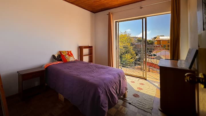 Соба со единечен кревет, биро, плакар, маса за појадок, лизгачки прозорец со пристап до терасата. Поглед кон ридот и заливот, на Авенида Алеманија.