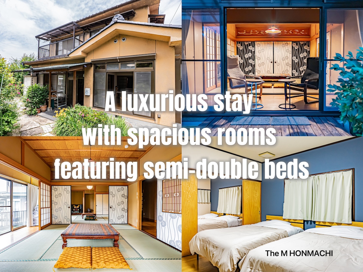 The image showcases a traditional Japanese house with a spacious outdoor area. It includes various rooms featuring semi-double beds and tatami mat flooring. Large windows allow natural light to fill the inviting spaces, while the fusion of modern amenities and traditional design is evident throughout the property.