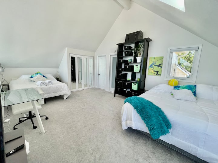 חדר שינה ראשי בלופט עם ארון כביסה, חדר ארונות וחדר רחצה יוקרתי.