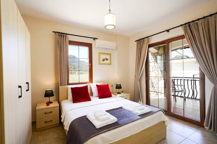 غرفة نوم مزدوجة أنيقة مع شرفة خاصة تطل على محيط جميل