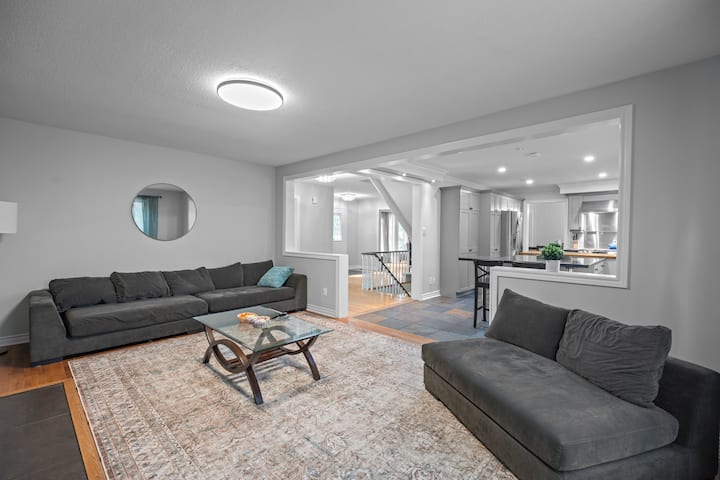 Примамлива семејна соба со монтиран телевизор, голем дел за седење и стаклена масичка за кафе. Светло и отворено со големи прозорци, елегантен декор и непречен проток до кујната - совршено за релаксирачки филмски вечери или секојдневни дружења.