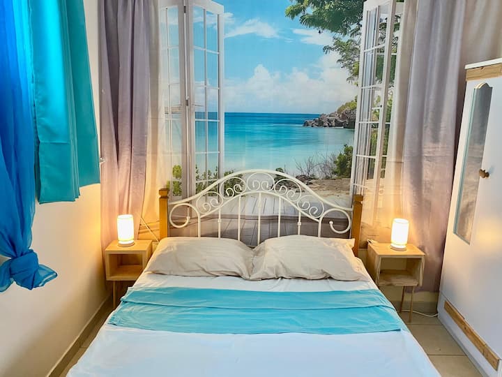 Плажата зад неа виси, но другата спална соба има прозорец со поглед на океан 