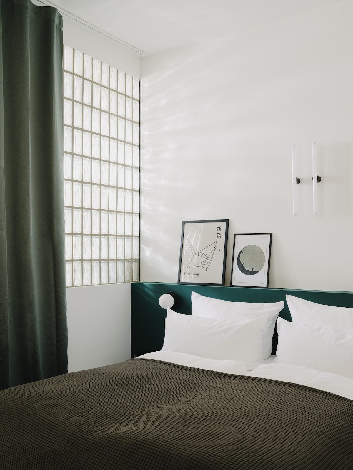 ห้องนอนที่มีผนังกระจกบล็อกและม่านทึบแสง