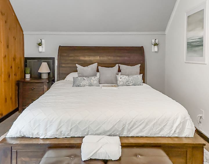 This master bedroom has a private balcony with seating and a master bath ensuite with rain head shower, double vanity, and walk-in closet.
