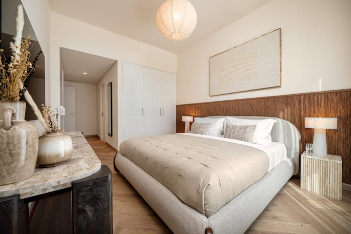 ห้องนอนหรูหราพร้อมเครื่องนอนหรูหรา การตกแต่งทันสมัย และแสงธรรมชาติที่สาดส่องเข้ามาจากหน้าต่างบานใหญ่