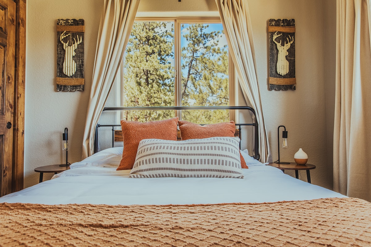 استمتع بالاستيقاظ على مناظر الغابة الخلابة في غرفة النوم المريحة هذه، التي تتميز بألوان ترابية دافئة ووسائد فخمة وإضاءة طبيعية ناعمة، مما يجعلها مثالية للاستمتاع بصباح هادئ وليالي مريحة.