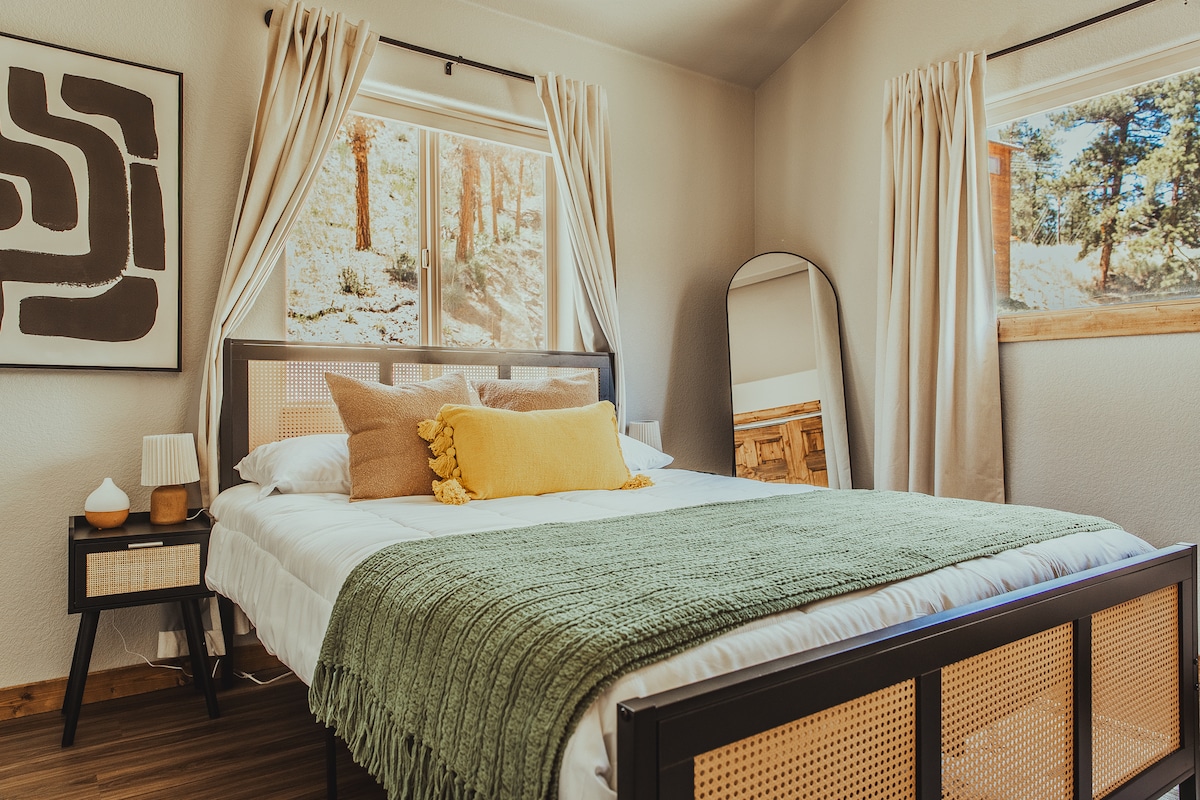 استرخ في غرفة النوم الرئيسية الهادئة، التي تتميز بألوان محايدة دافئة، وملمس ناعم، وإطلالات هادئة على الغابة - مع مرآة كاملة الطول وديكور أنيق لقضاء عطلة مريحة وراقية في الجبال.