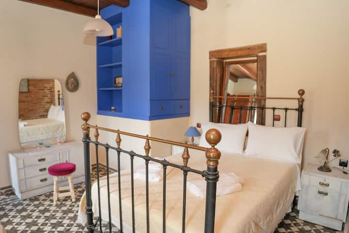 חדר שמשלב בין הישן לחדש. המיטה מברזל, המצעים הלבנים והגוונים הכחולים הבולטים יוצרים תחושה של אלגנטיות ותוססות. מושלם לשינה נינוחה במרחב שמעורר שלווה ואותנטיות.