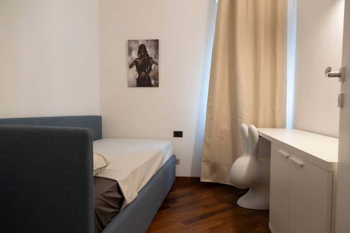 غرفة نوم فردية ثانية. خطوط نظيفة وألوان محايدة ووسائل راحة أساسية: يوفر الحمام دشًا كبيرًا ومفروشات عصرية وكل ما تحتاجه لإقامة مريحة. دائمًا نظيف تمامًا ورصين مع الاهتمام بالتفاصيل