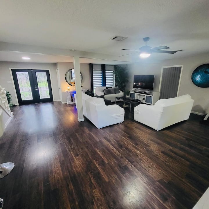 Sebule yenye nafasi kubwa yenye viti vingi kwa ajili ya familia nzima, mwangaza mzuri wa asili, televisheni ya burudani, ufikiaji wa moja kwa moja wa chumba cha chini na mashine ya kukanyaga kwa ajili ya mazoezi.