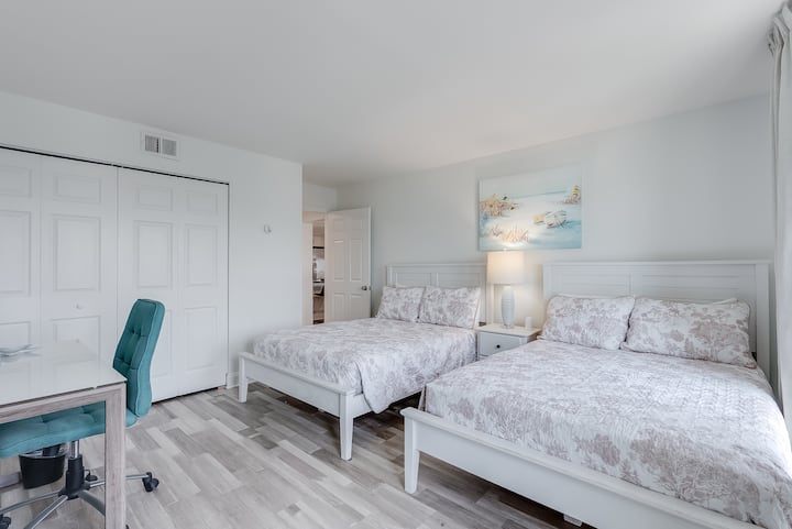 2 lits doubles pour plus d'espace de couchage avec des fenêtres partout et un accès au balcon. Comprend aussi de l'espace de rangement et un placard.