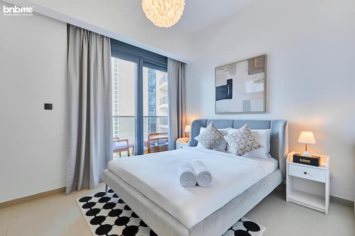 Relájate en el elegante segundo dormitorio, que cuenta con una lujosa cama tamaño queen, una decoración elegante y acceso a un balcón con impresionantes vistas al perfil urbano del centro de Dubái, perfecto para descansar al atardecer.