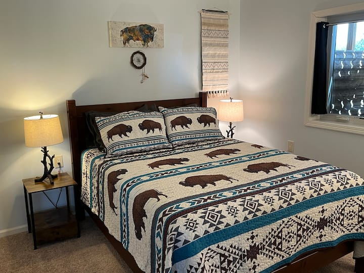 Dormitorio tamaño queen con temática de búfalo.