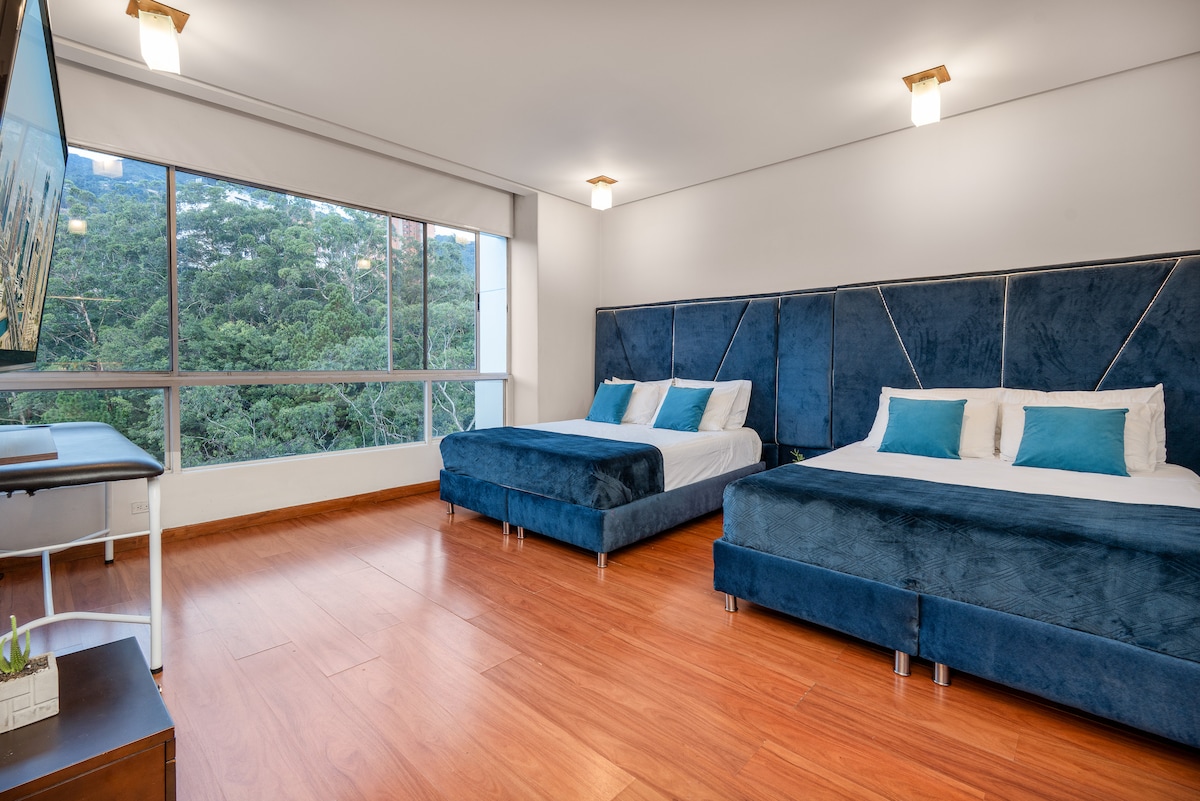 Esta habitación cuenta con dos camas dobles de gran tamaño, incluye televisor de pantalla plana, escritorio de trabajo y amplios espacios para guardar pertenencias, haciendo que la estancia sea práctica y confortable.