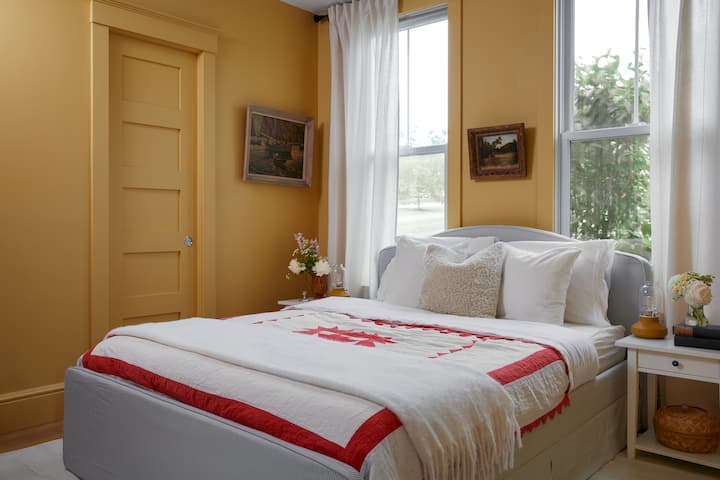 The Marigold Suite. Cozy queen bed and and little bathroom tucked behind the pocket door.